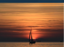 Velero en Santa Pola con puesta de sol y nubes