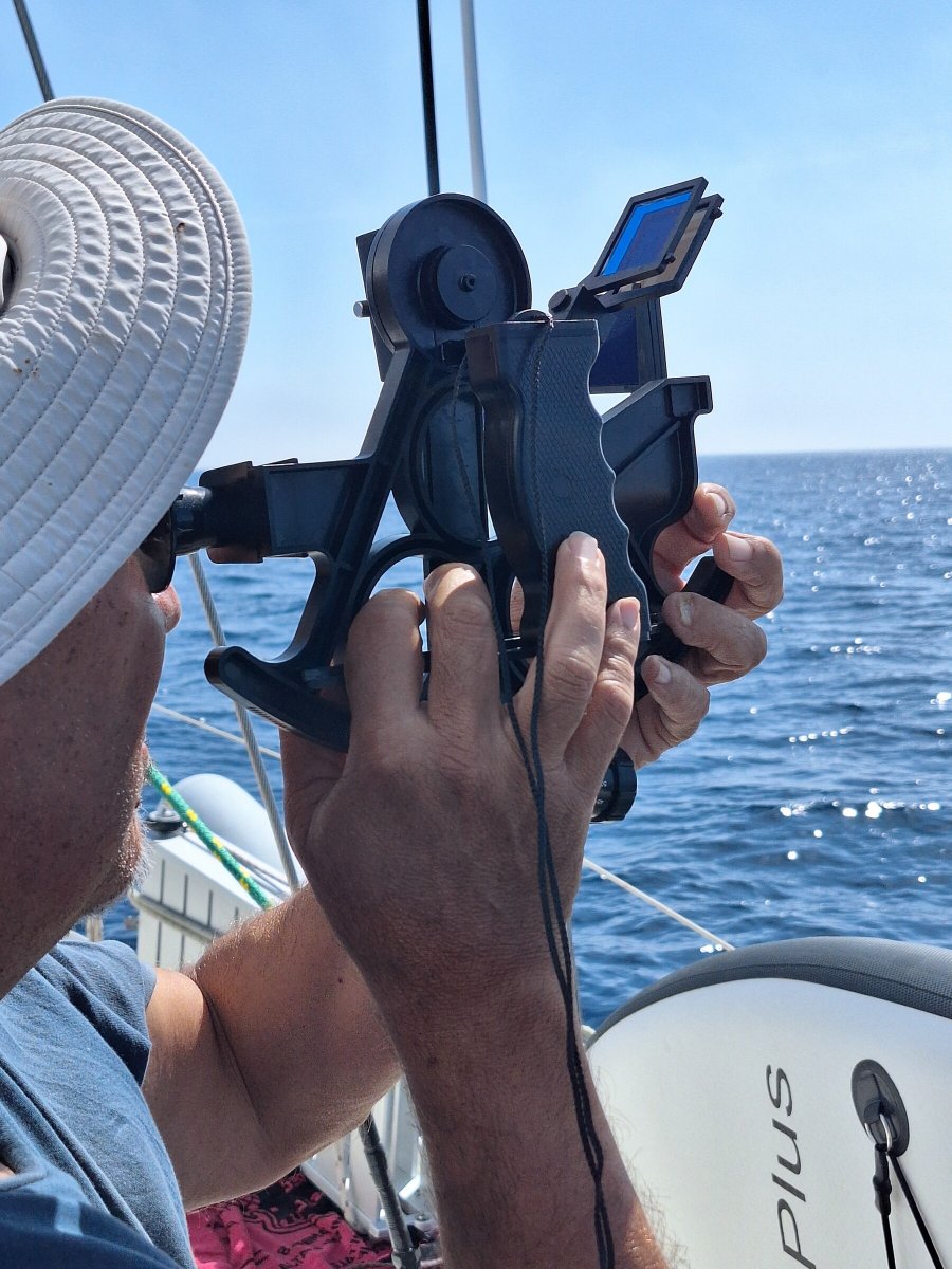 Barca a vela che passa sotto il ponte della Torre del Fanale