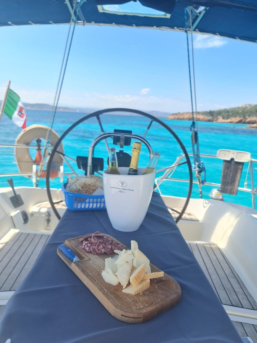 Paseo en Barco por el Atardecer en Capo Testa con Música en Vivo y Aperitivos