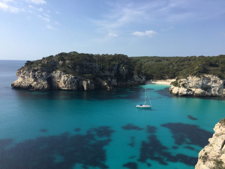 Turismo sostenible en velero navegando por Cala Macarelleta en la costa menorquina