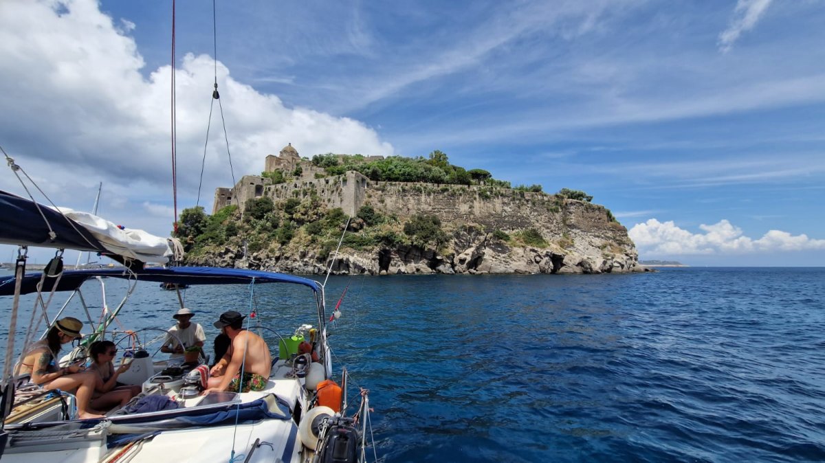 Barca a vela in mare con onde verdi