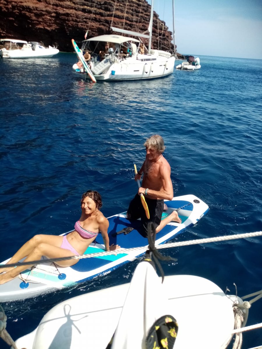 Barca a vela nel Mediterraneo con montagne sullo sfondo