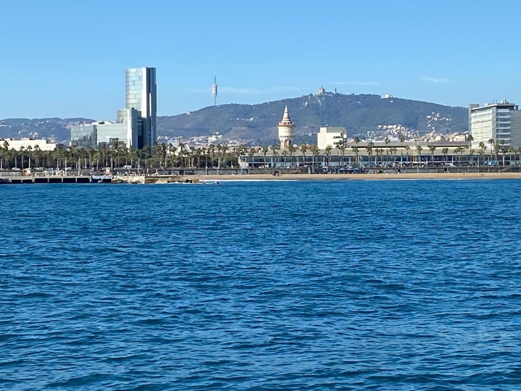 Eine Person, die auf einem Segelboot auf dem Meer in der Nähe von Barcelona segelt
