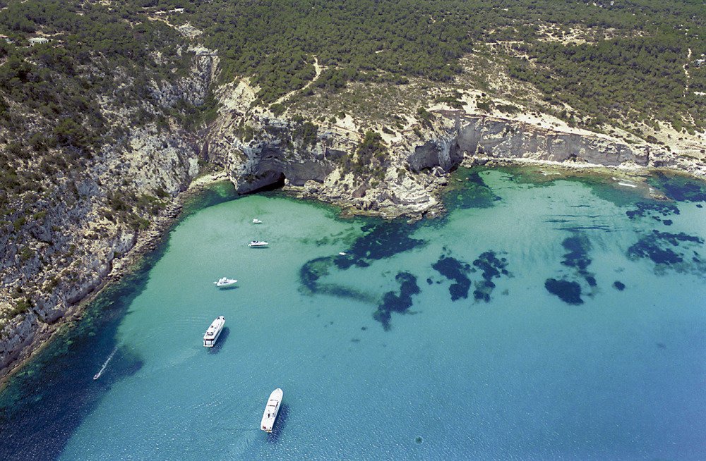 Dal porto di La Savina, partiamo verso Es Caló, un'incantevole insenatura con acque cristalline e paesaggi da sogno.