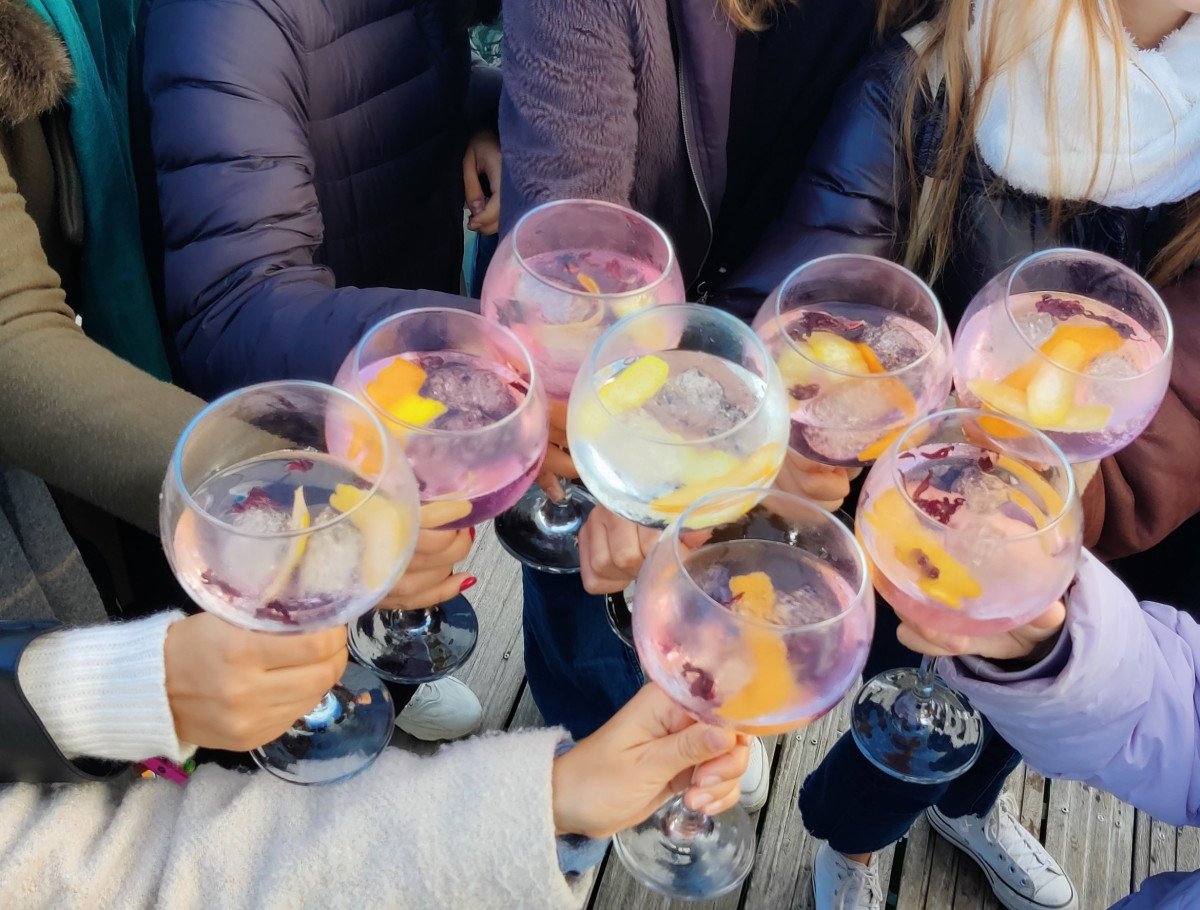 Gruppo di persone che godono del tramonto sulla barca a vela