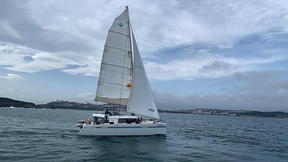 Un catamarán en la bahía de Santander con la ciudad de fondo
