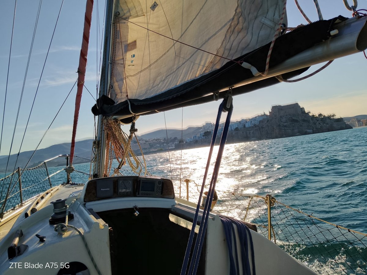 Una barca a vela che naviga lungo la costa di Peñíscola