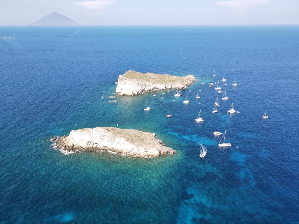 Una vista aerea delle isole Eolie, con barche a vela che solcano le sue acque