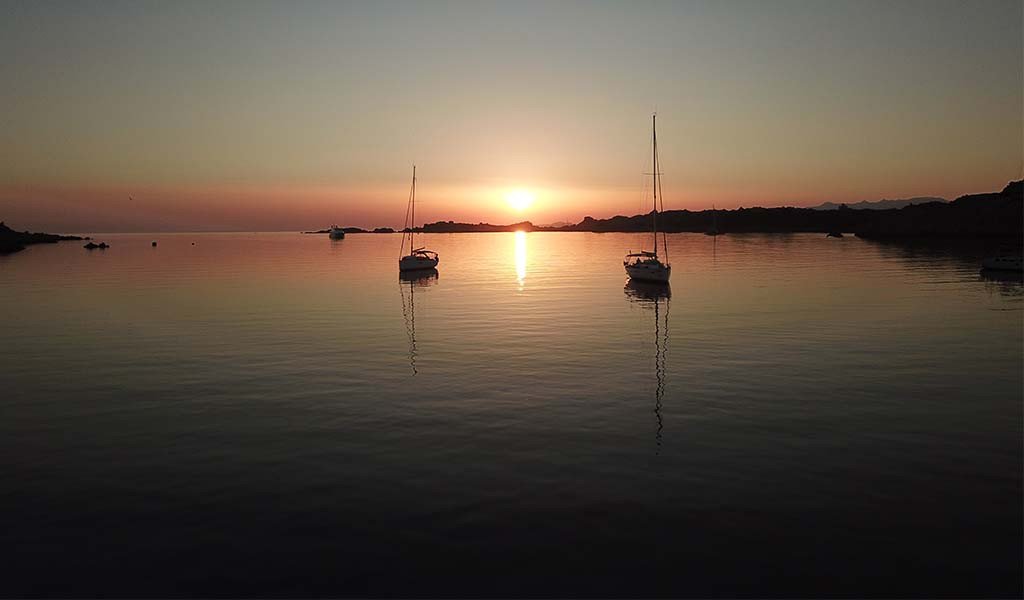 Entdecken Sie Capo Testa bei Sonnenuntergang mit einer Bootstour mit Live-Musik und Aperitifs