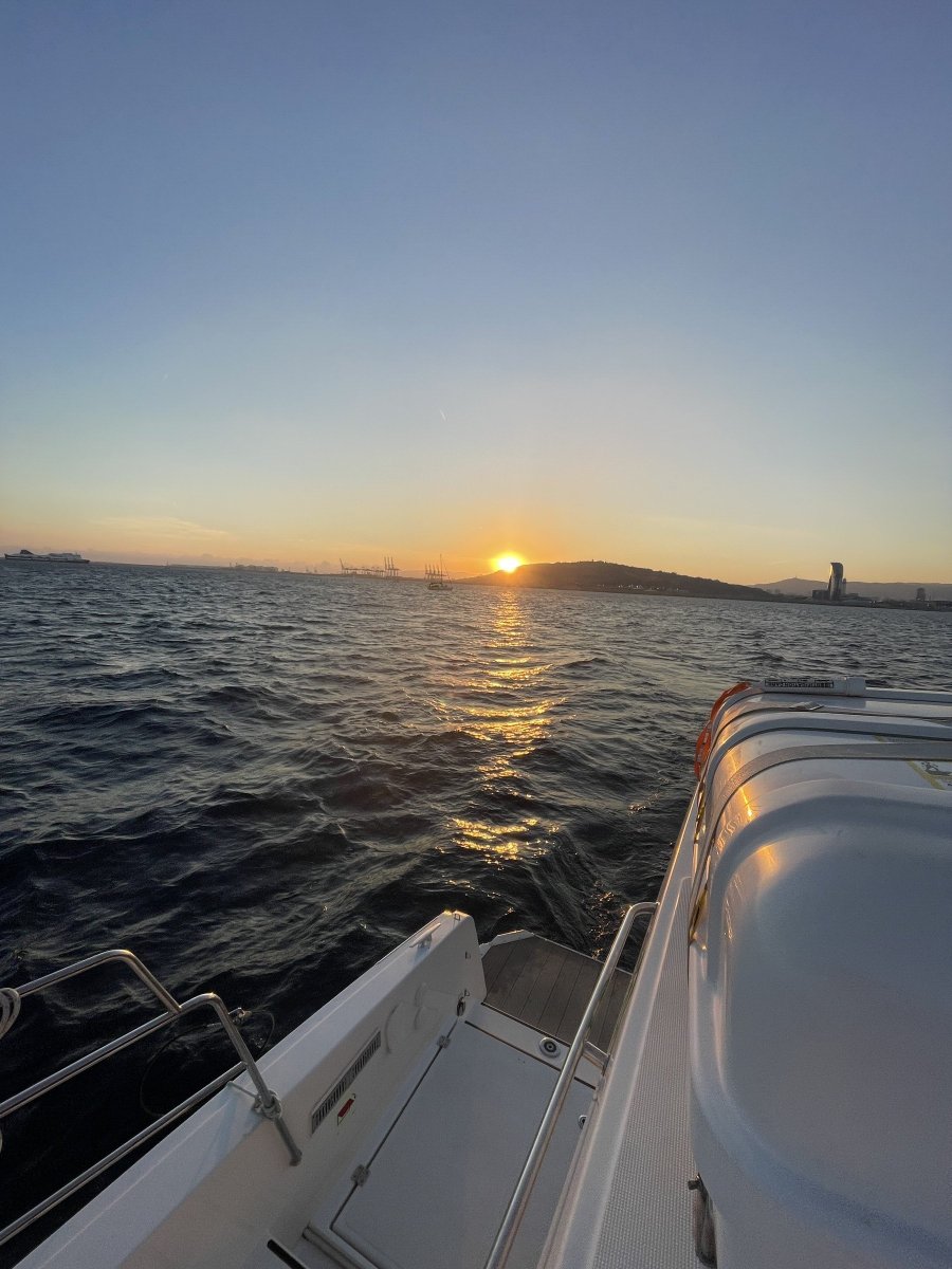 Barca che naviga al tramonto a Barcellona
