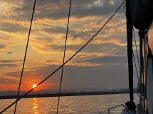 Una barca a vela che naviga al tramonto a Barcellona