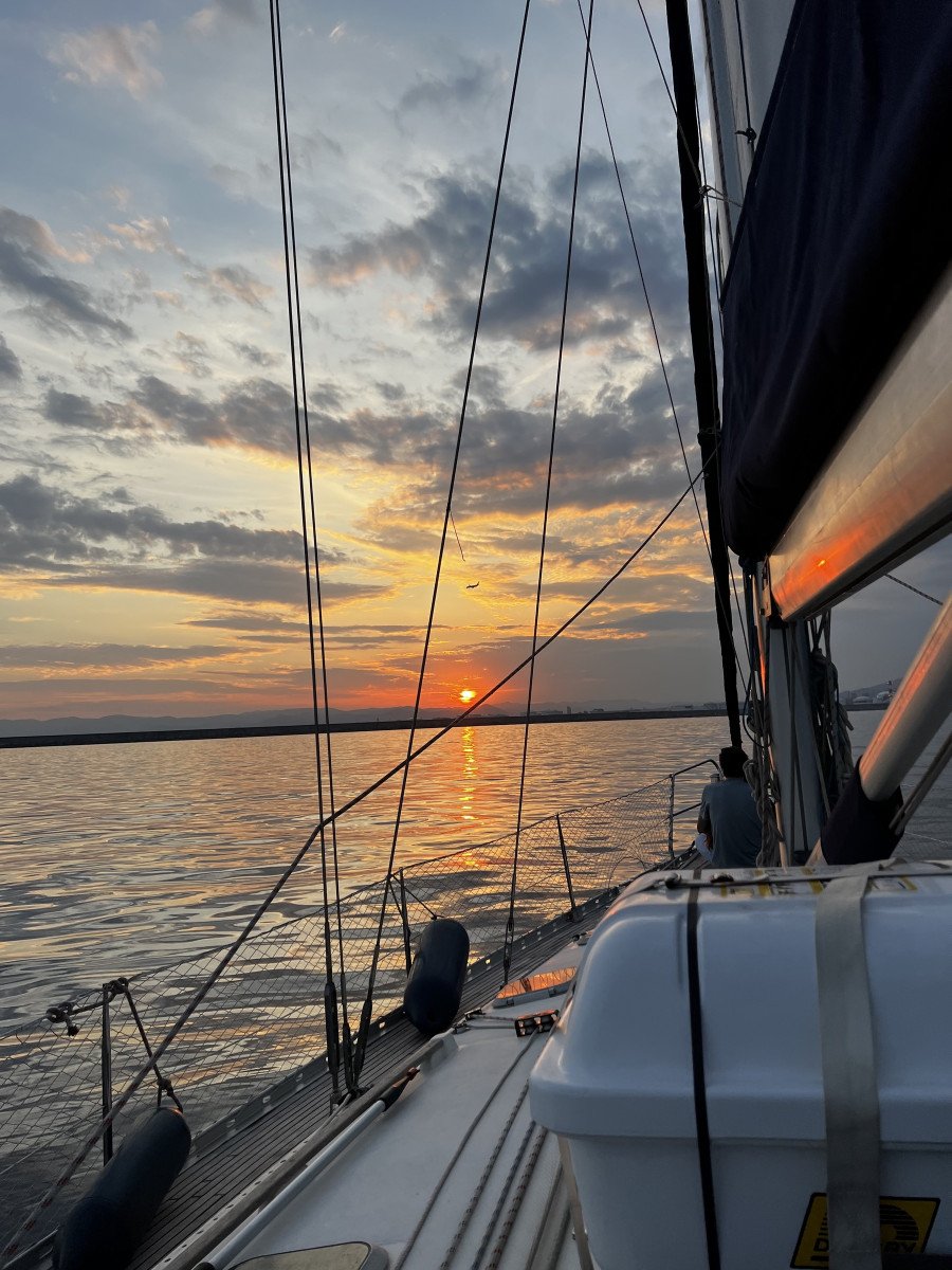 Una barca a vela che naviga in mare durante il tramonto