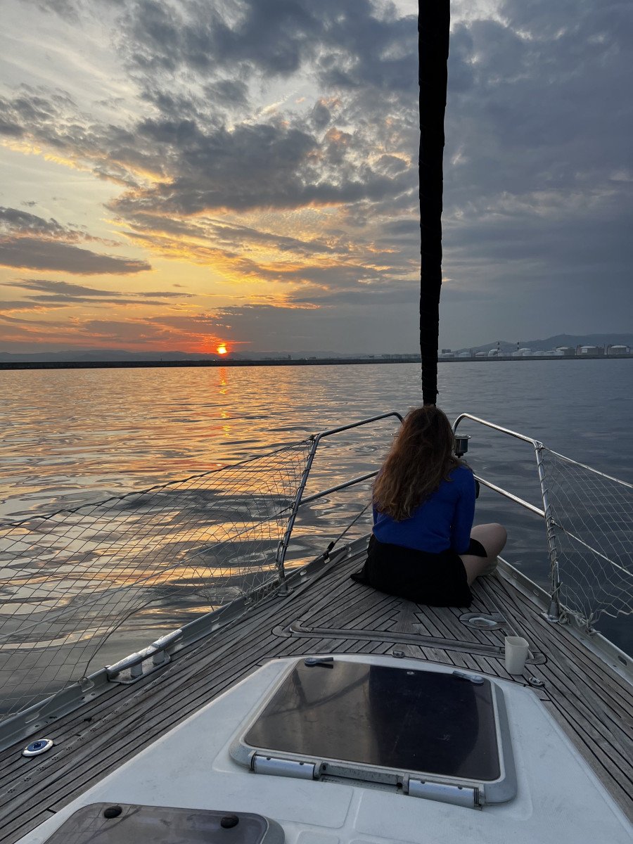 A sailboat with the sunset on the horizon