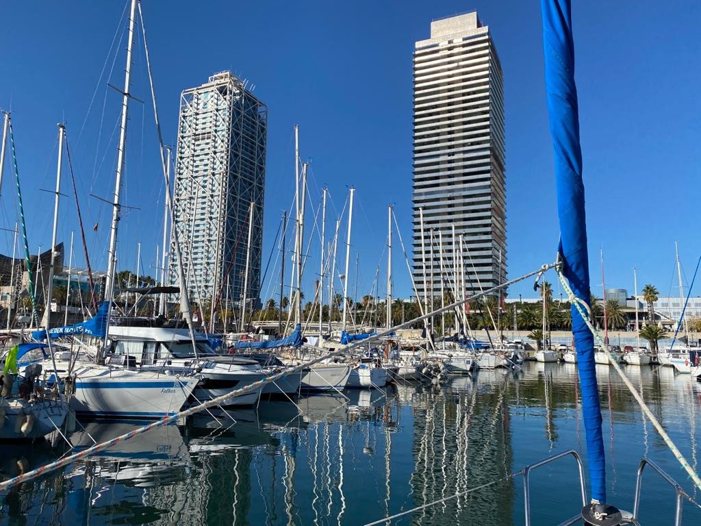 Dos personas disfrutando del sol en un velero en Barcelona