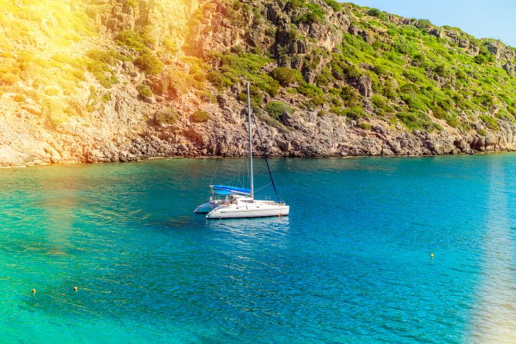Un catamarán navega cerca de la costa